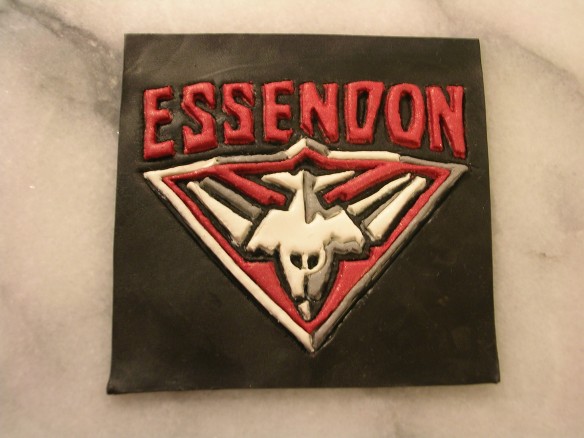 Coaster with stencil design of Essendon AFL team logo